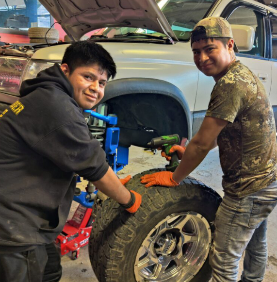 mechanics holding a tire